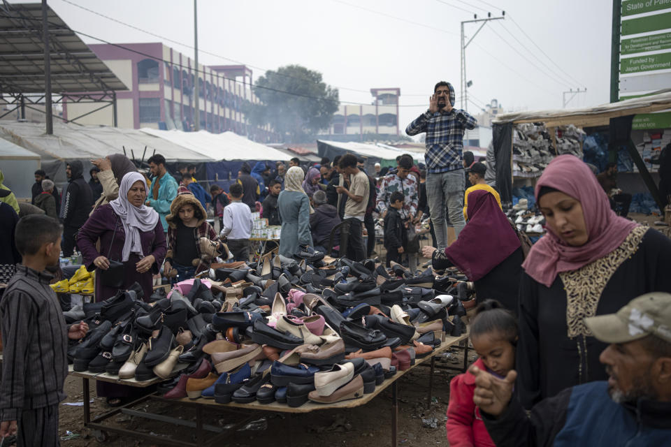 A man sells shoes at a makeshift tent camp for Palestinians displaced by the Israeli bombardment of the Gaza Strip, in the Muwasi area on Thursday, Dec. 28, 2023. (AP Photo/Fatima Shbair)