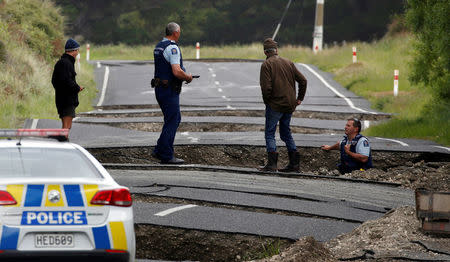 Policemen and locals look at damage following an earthquake, along State Highway One near the town of Ward, south of Blenheim on New Zealand's South Island, November 14, 2016. REUTERS/Anthony Phelps