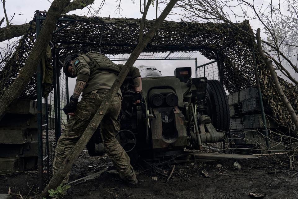 A Ukrainian soldier fires a cannon near Bakhmut (AP)