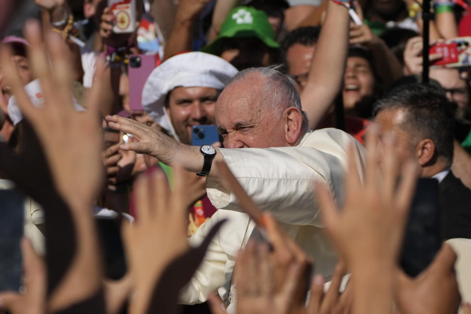 Pope Francis waves on arrival to take part in a via crucis (Way of the Cross) at the Eduardo VII Park with young people in Lisbon, Friday, Aug. 4, 2023. Pope Francis is on the third day of a five-day pastoral visit to Portugal that includes the participation at the 37th World Youth Day, and a pilgrimage to the holy shrine of Fatima. (AP Photo/Gregorio Borgia)