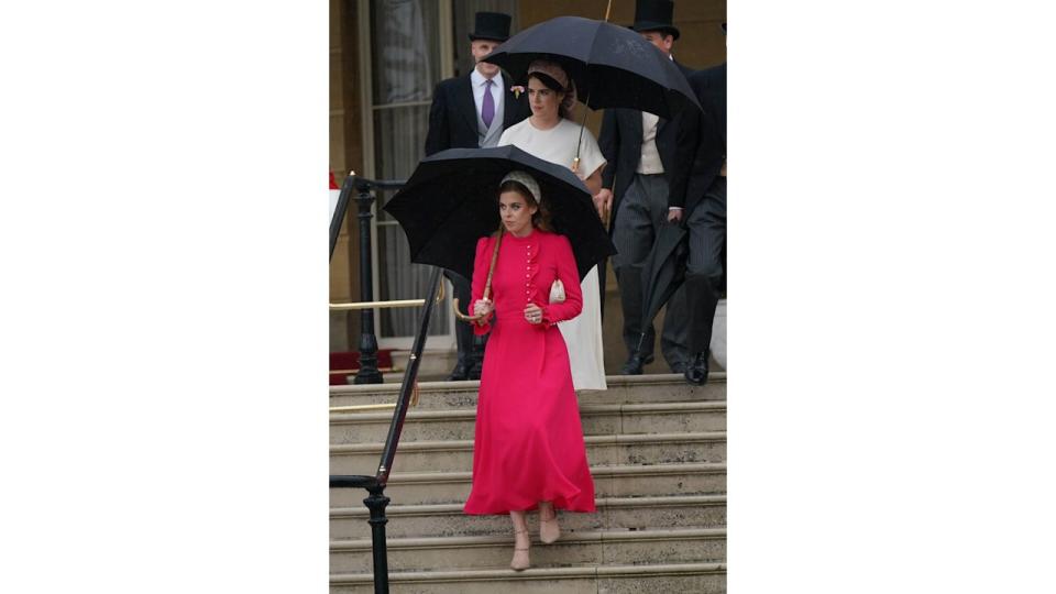 Princess Beatrice in a vibrant pink dress holding umbrella