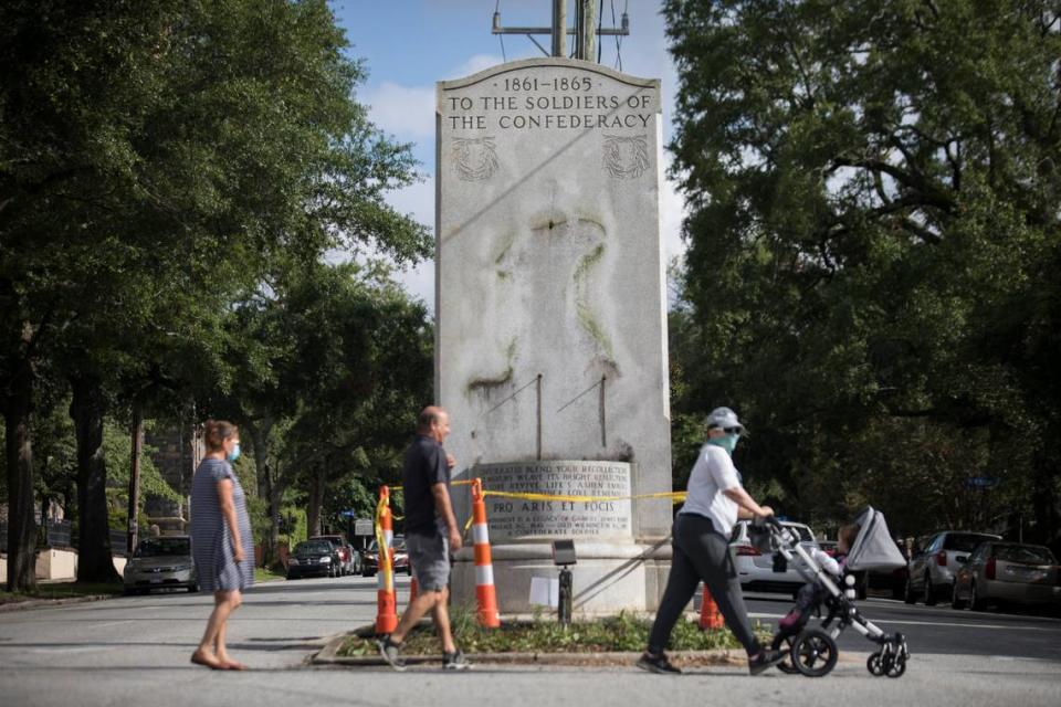 People in downtown Wilmington, N.C. walk past the Confederate memorial where the outline of a solider statue can be seen on Thursday, June 25, 2020. It was one of two Confederate statues removed from their pedestals in the port city overnight after Wilmington Police Chief Donny Williams announced on Wednesday that three officers would be fired for making racist and threatening comments that were caught on a dash cam video seen during an audit.