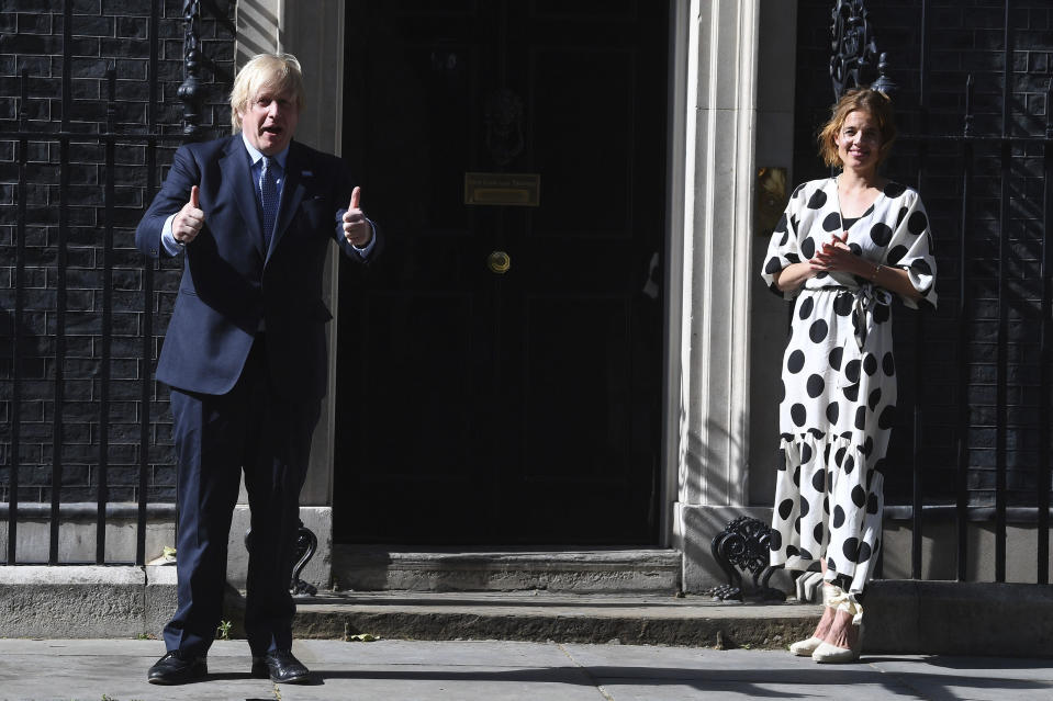 Britain's Prime Minister Boris Johnson and Annemarie Plas, founder of Clap For Our Carers, join in the pause for applause to salute the NHS 72nd birthday, outside 10 Downing Street in London, Sunday, July 5, 2020. People across the U.K. joined a round of applause to celebrate the 72nd anniversary of the formation of the free-to-use National Health Service, undoubtedly the country’s most cherished institution. The reverence with which it is held has been accentuated this year during the coronavirus pandemic. (Victoria Jones/PA via AP)