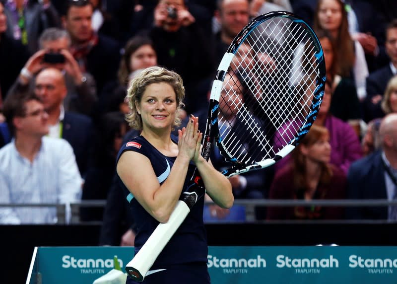 FILE PHOTO: Belgium's Clijsters applauds after receiving a giant racket during an exhibition tennis match marking the end of her professional career in Antwerp