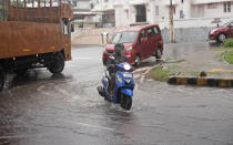 A man rides his scooter during heavy rainfall in Kochi, Kerala state, India, Friday, Aug. 7, 2020. A mudslide triggered by heavy monsoon rain and flooding killed at least five people in the state on Friday, police said. (AP Photo/R S Iyer)