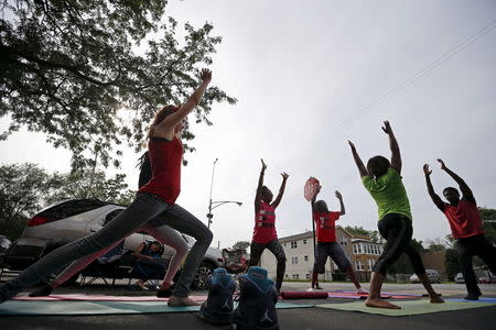 Mothers Against Senseless Killings (MASK) founder Tamar Manasseh (C) takes part in a yoga class on a street intersection in the Englewood neighborhood of Chicago, Illinois, United States, August 5, 2015. REUTERS/Jim Young