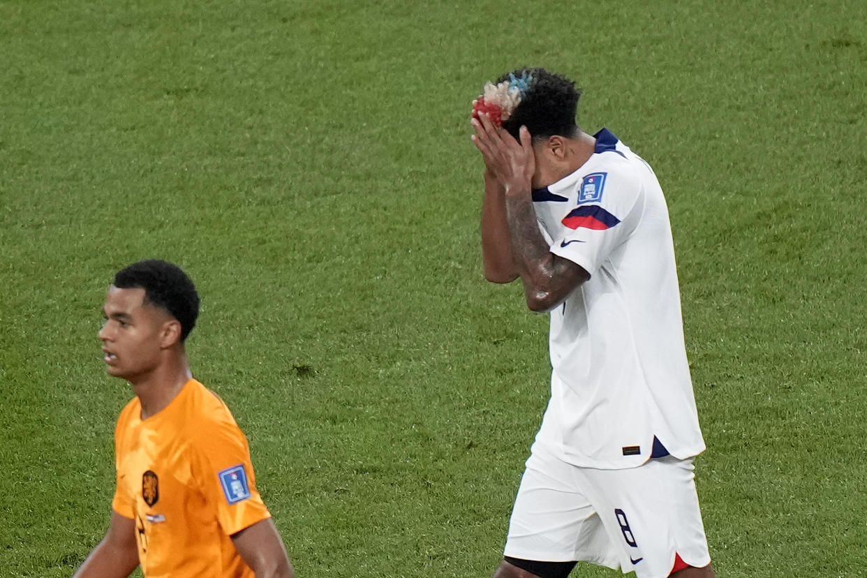 Weston McKennie of the United States reacts next to Cody Gakpo of the Netherlands, left, during the World Cup round of 16 soccer match between the Netherlands and the United States, at the Khalifa International Stadium in Doha, Qatar, Saturday, Dec. 3, 2022. (AP Photo/Luca Bruno)