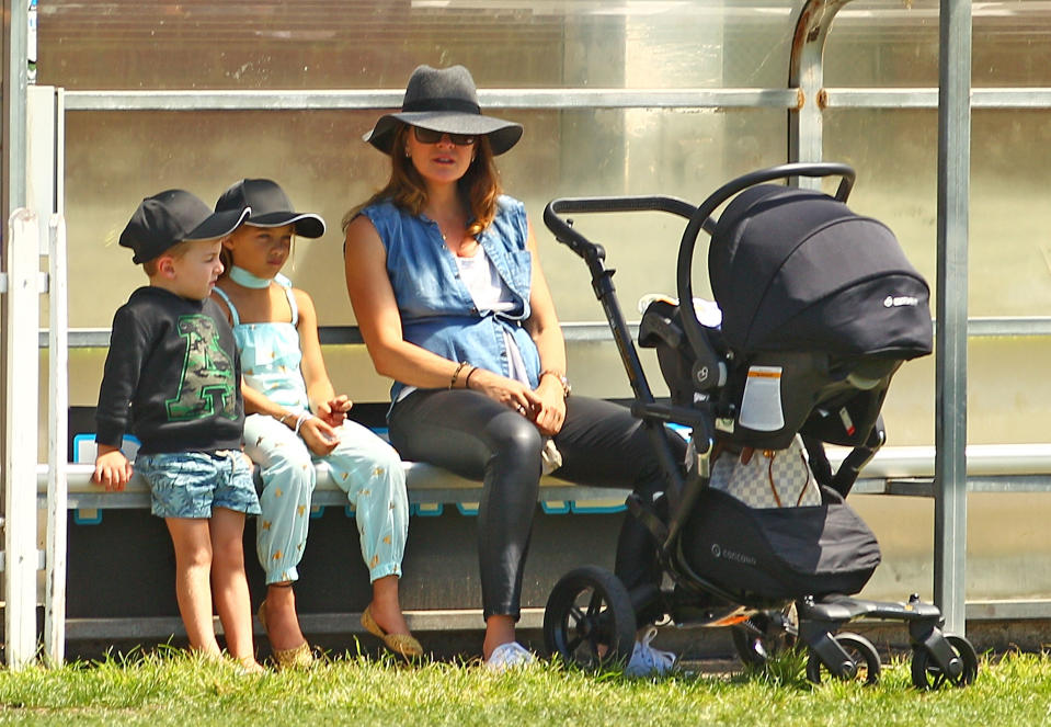 Michelle Bridges with her baby Axel in his pram looks on with Ella and Jack, the children of Steve Willis, also known as The Commando during the Medibank Melbourne Celebrity Twenty20 match at North Port Oval on February 21, 2016 in Melbourne, Australia.