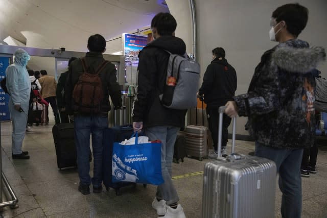 Passengers leave a train from Beijing after it arrives in Wuhan