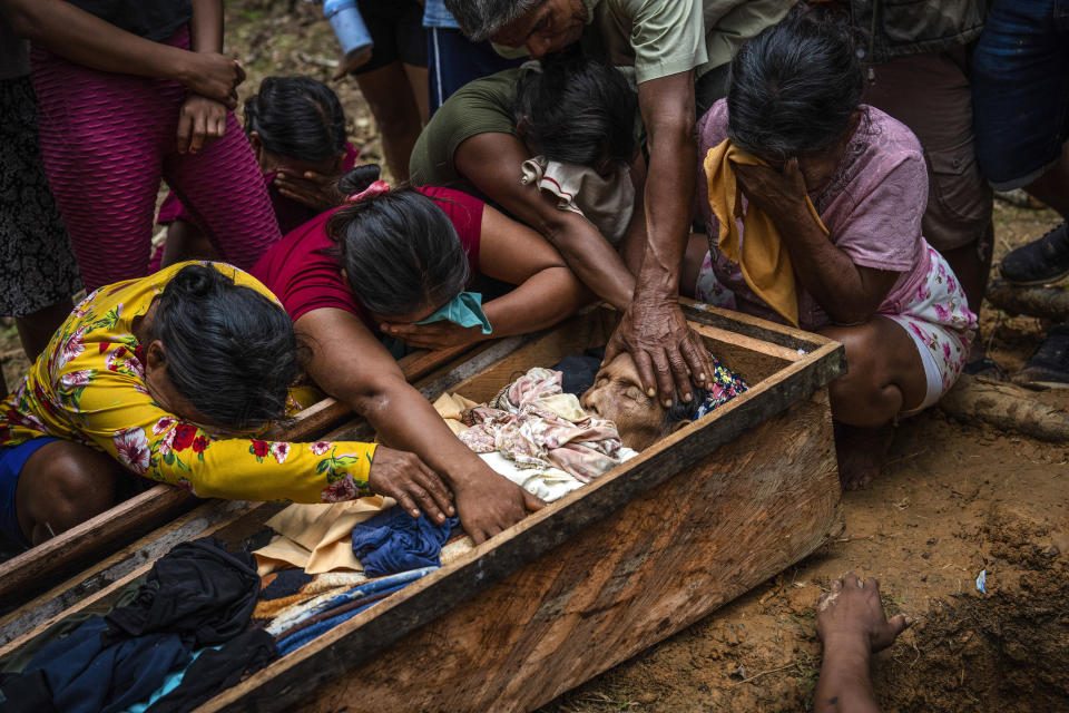 Maijuna mourners gather around the coffin that contains the remains of Rosario Rios during her burial service in the cemetery of Sucusari, Peru, Wednesday, May 29, 2024. A federal highway project in an untouched area of the Peruvian Amazon is facing mounting opposition from Indigenous tribes, including the Maijuna. (AP Photo/Rodrigo Abd)