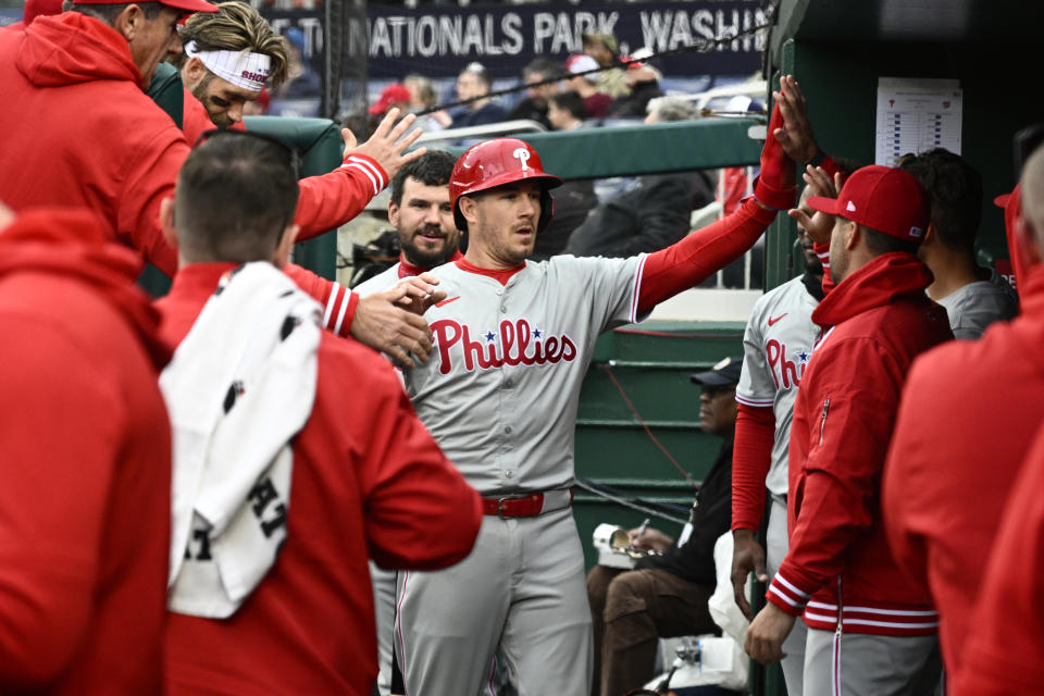Philadelphia Phillies' J.T. Realmuto, center, celebrates after he scored on a triple by teammate Alec Bohm during the second inning of a baseball game against the Washington Nationals, Saturday, April 6, 2024, in Washington. (AP Photo/Nick Wass)