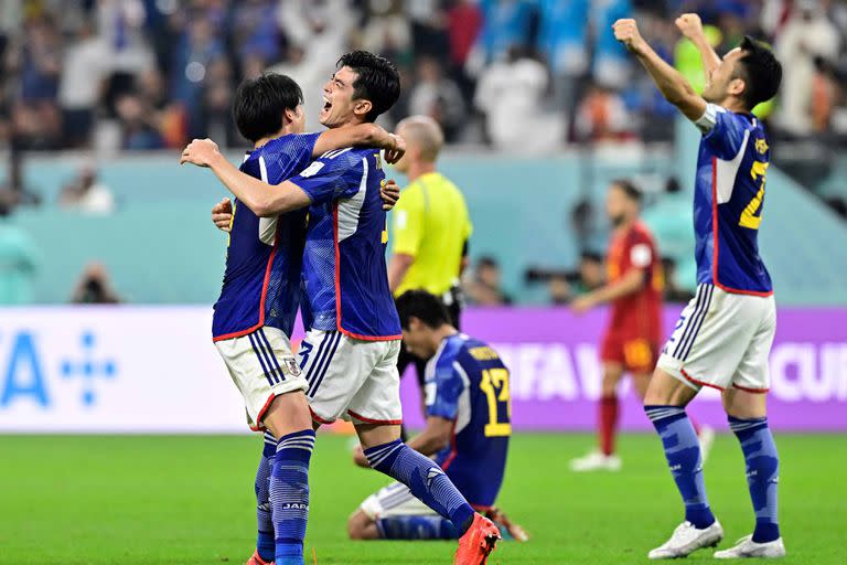 Japan's teammates celebrate after winning the Qatar 2022 World Cup Group E football match between Japan and Spain at the Khalifa International Stadium in Doha on December 1, 2022. (Photo by JAVIER SORIANO / AFP)