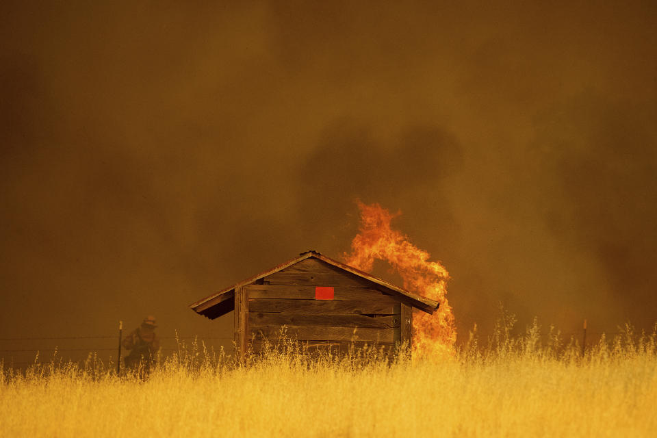 <p>Flames rise above outbuilding as the County fire burns in Guinda, Calif., July 1, 2018.(Photo: Noah Berger/AP) </p>