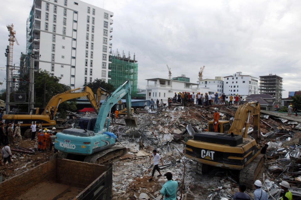 Rescuers try to remove the rubble at the site of a collapsed building in Preah Sihanouk province, Cambodia, Sunday, June 23, 2019. Rescue workers were using saws to cut steel beams and excavators to move piles of rubble of the collapsed seven-story building. (AP Photo/Heng Sinith)