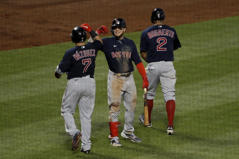 Boston Red Sox's Alex Verdugo, center, celebrates with Christian Vazquez, left, and Xander Bogaerts after Bogaerts hit a two-run homer run during the fourth inning of the baseball game against the New York Mets at Citi Field, Thursday, July 30, 2020, in New York. (AP Photo/Seth Wenig)