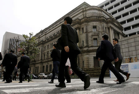 Businessmen walk past the Bank of Japan (BOJ) building in Tokyo, Japan, March 23, 2016. REUTERS/Toru Hanai/File Photo