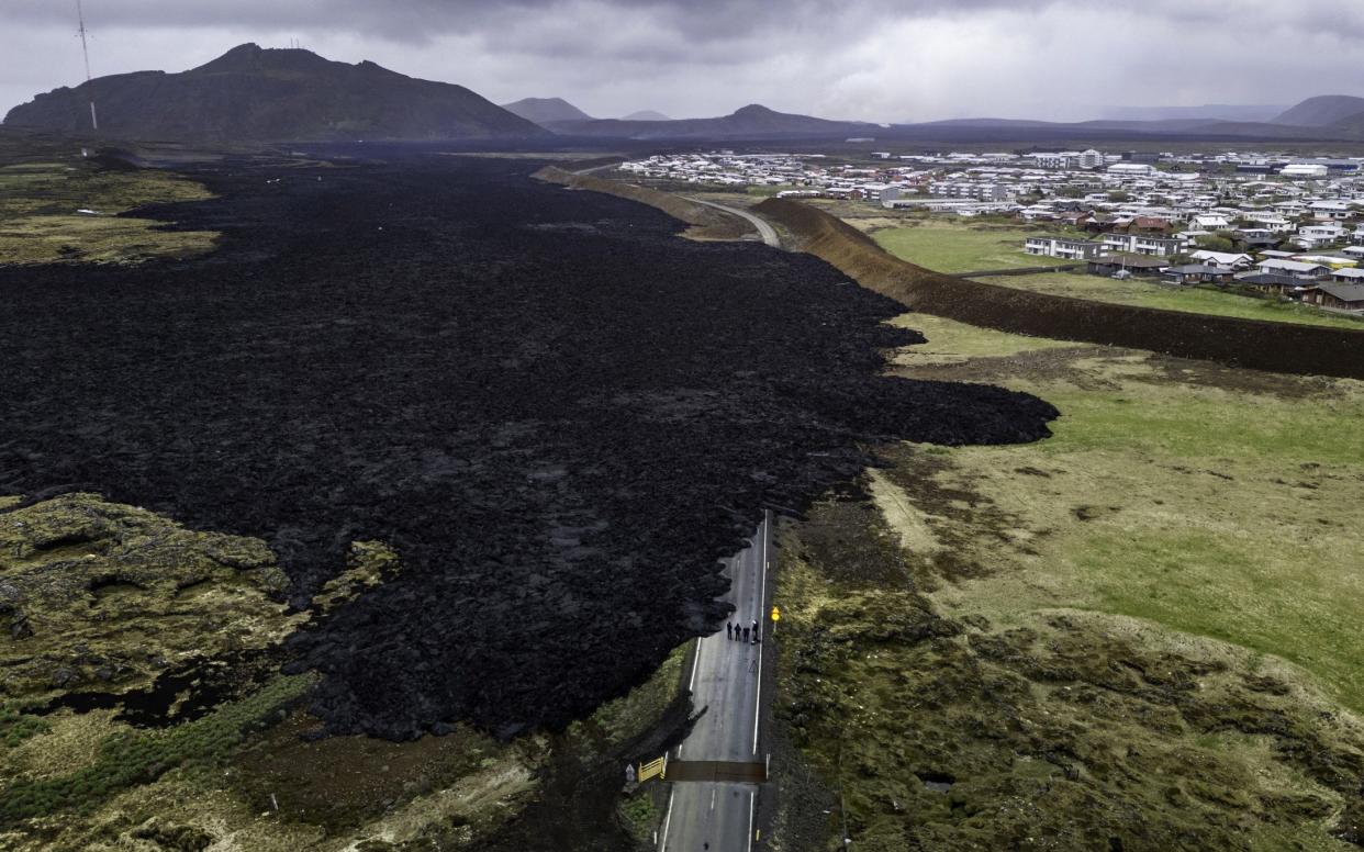 Destroyed cooling lava cuts off a road into Grindavik after a volcano erupted for the fifth time since December on the Reykjanes peninsula