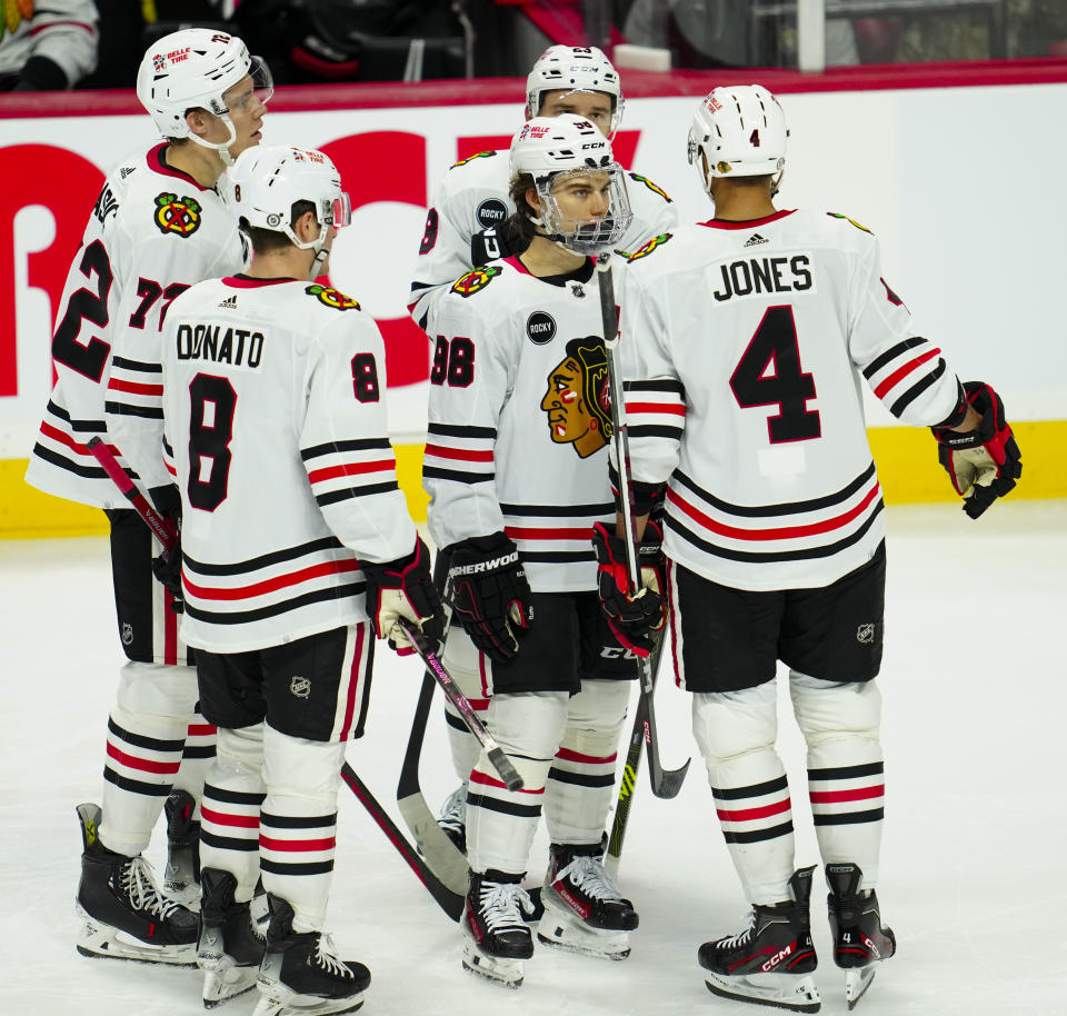 Chicago Blackhawks center Connor Bedard (98) talks with teammates during a break in play against the Ottawa Senators during the second period of an NHL hockey game in Ottawa, Ontario, on Thursday, March 28, 2024. (Sean Kilpatrick/The Canadian Press via AP)