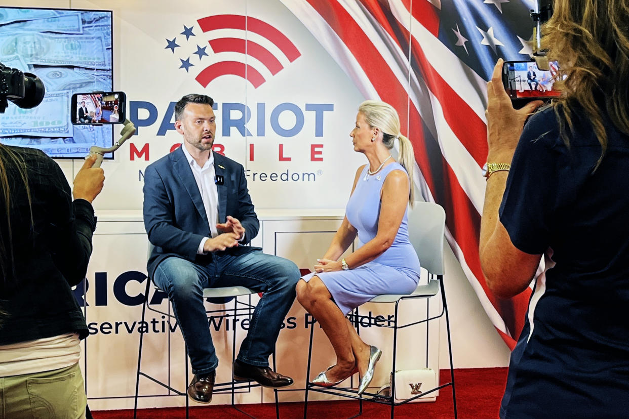Leigh Wambsganss interviews pro-Trump conspiracy theorist Jack Posobiec at the Patriot Mobile booth at CPAC in Dallas on Aug. 4. (Mike Hixenbaugh / NBC News)
