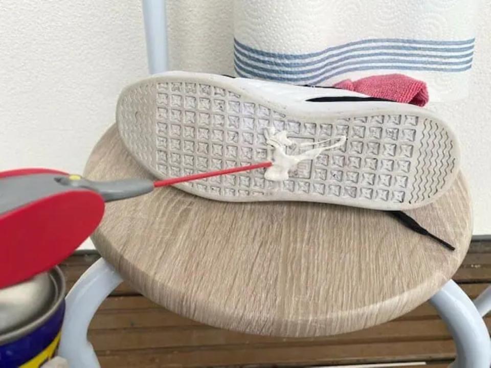 Using WD40 to remove gum from the sole of a white sneaker.