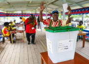 A man raises his hands as he prepares to cast a vote in Buka, the Autonomous Region of Bougainville, Papua New Guinea, Saturday, Nov. 23, 2019, in a historic referendum to decide if they want to become the world's newest nation by gaining independence from Papua New Guinea. (Post Courier via AP)