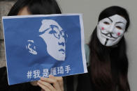 A supporter holds a placard with picture of Hong Kong activist Edward Leung and Chinese words which mean "I am a protector of Edward Leung," outside the High Court in Hong Kong, Wednesday, Oct. 9, 2019. Last year, Leung was sentenced to six years in prison for his part in a violent nightlong clash with police over illegal street food hawkers two years ago. (AP Photo/Kin Cheung)