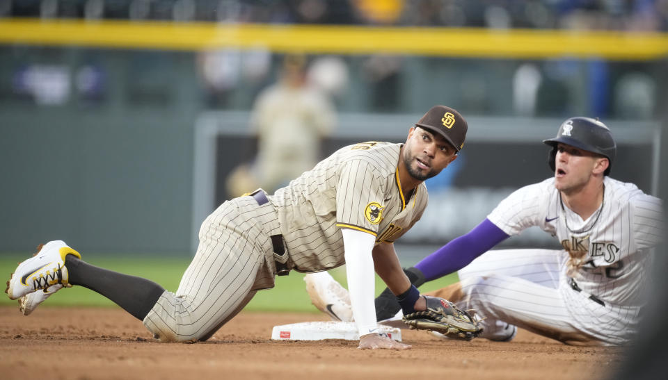 San Diego Padres shortstop Xander Bogaerts, left, applies a late tag to Colorado Rockies' Nolan Jones as he steals second base in the fifth inning of a baseball game Friday, June 9, 2023, in Denver. (AP Photo/David Zalubowski)