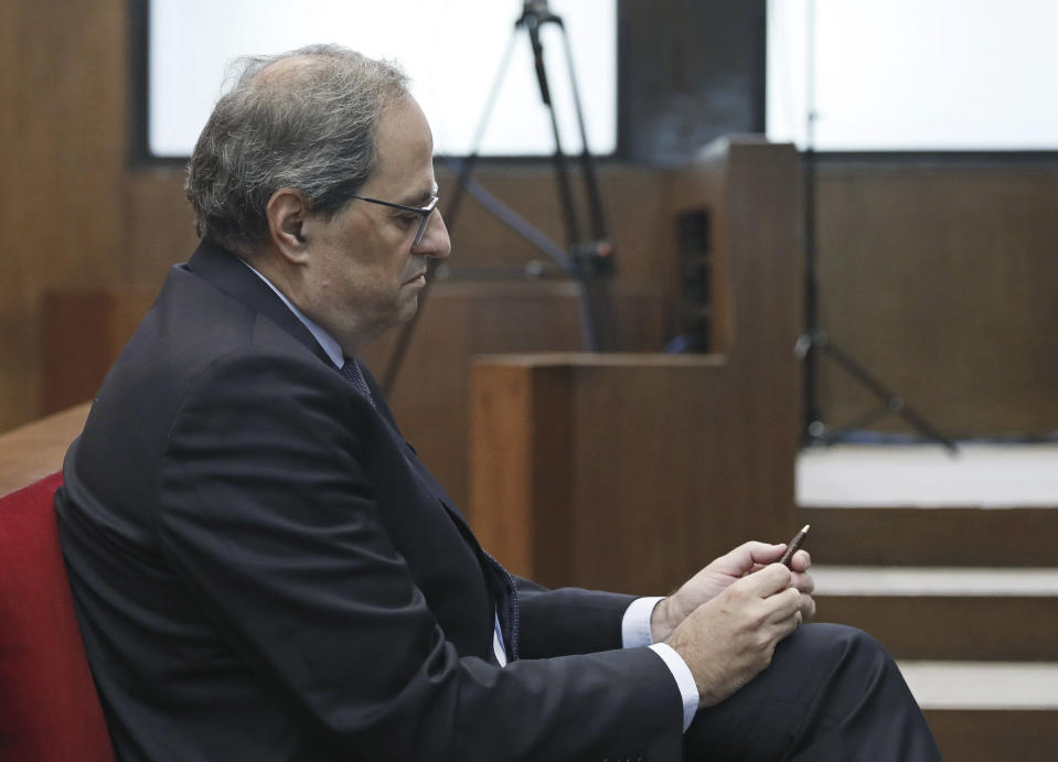 Catalan President Quim Torra sits in court in Barcelona, Spain, Monday, Nov.18, 2019. The pro-independence regional president of Catalonia is standing trial for allegedly disobeying Spain's electoral board by not removing pro-secession symbols from public buildings during an election campaign. Quim Torra could be declared unfit to hold public office for a period of time if found guilty in the trial that started Monday. (Andreu Dalmau, Pool photo via AP)