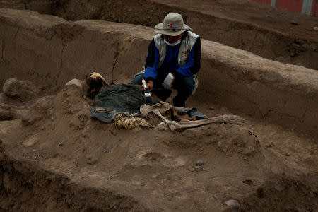 Archaeologist works at a tomb of one of sixteen Chinese migrants, discovered buried at the turn of the 20th century in the pre-colombian pyramid of Bellavista, according to Ministry of Culture, in Lima, Peru, August 24, 2017. REUTERS/Mariana Bazo