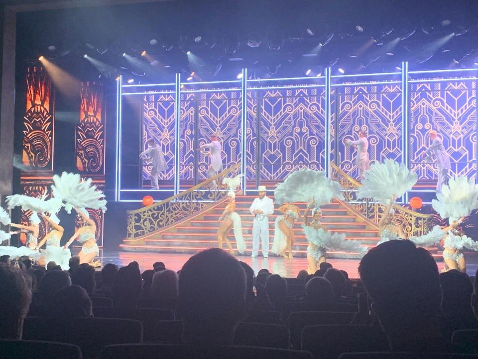 shwogirls with feathers in front of backdrop