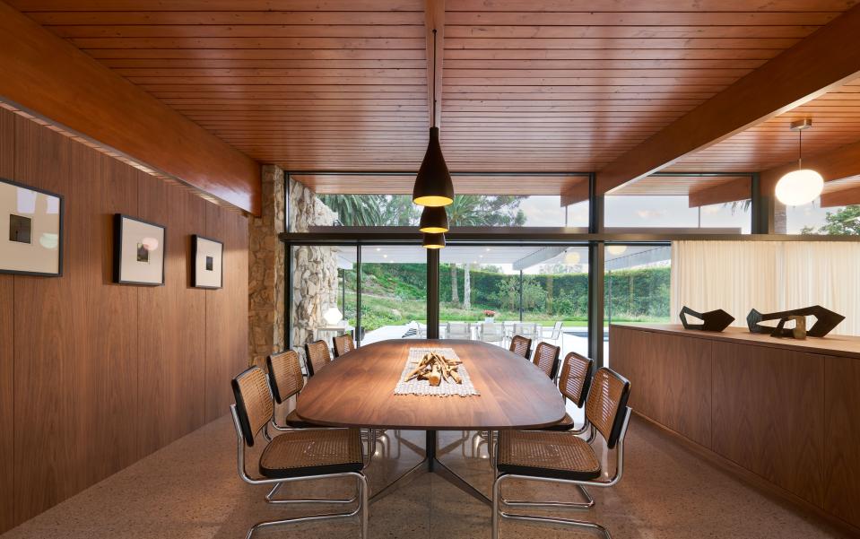 “We didn’t want any kind of furniture or millwork that didn’t fit with the house,” says Lynch, who divided the dining space from the living room with a low walnut piece he designed. That feature serves as both storage and a mode of ensuring privacy while sitting at the custom-designed table. The surrounding chairs are from Knoll.