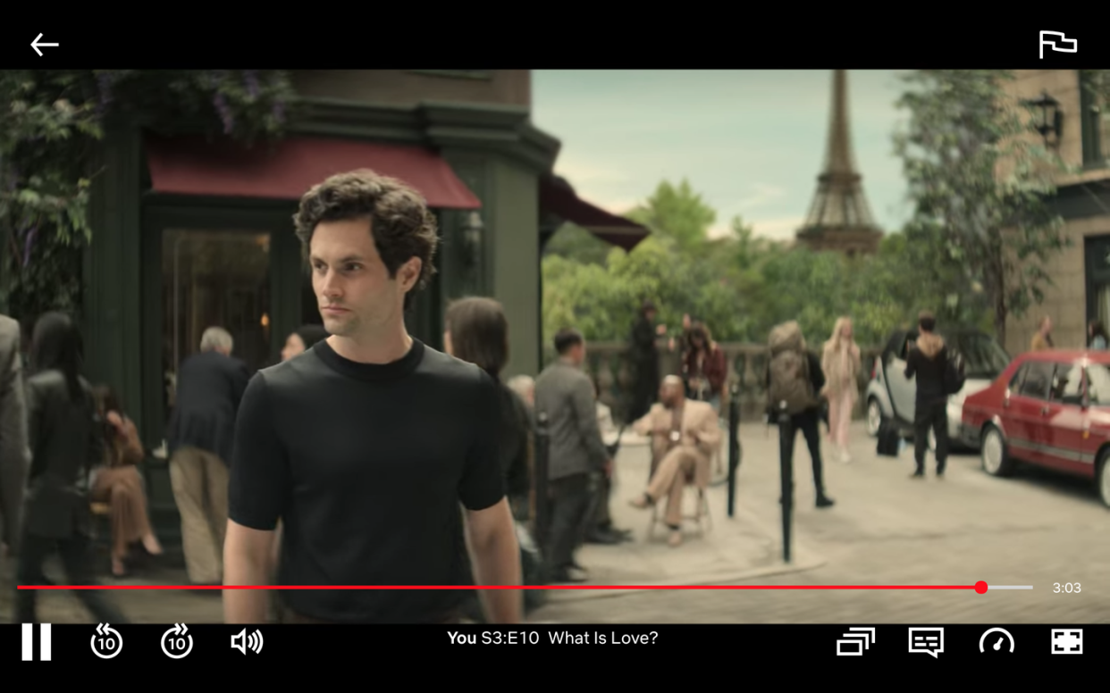 penn badgley walking the streets of paris in a scene from you season 3