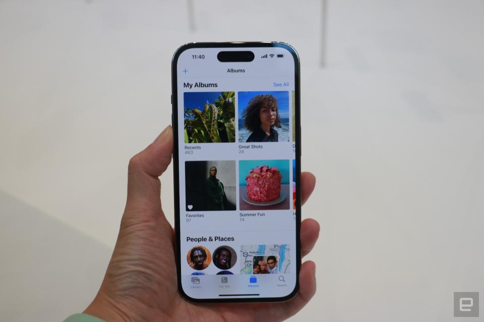 <p>The iPhone 14 Pro held in mid-air, showing the new dynamic island at the top of the Photos app.</p>
