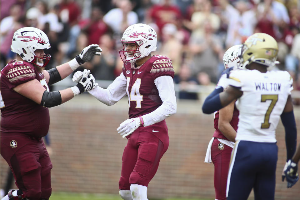 Florida State offensive lineman Dillan Gibbons (75) congratulates wide receiver Johnny Wilson (14) after his touchdown in the second quarter of an NCAA college football game Saturday, Oct. 29, 2022, in Tallahassee, Fla. (AP Photo/Phil Sears)