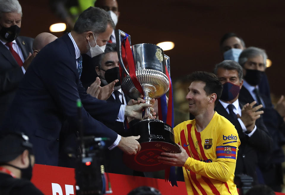 El Rey Felipe de España entrega la Copa del Rey al argentino Lionel Messi, del Barcelona, tras la final ante el Athletic de Bilbao, disputada el sábado 17 de abril de 2021 en Sevilla (AP Foto/Angel Fernández)