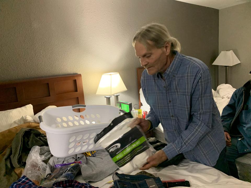 At his temporary lodging inside the Baymont Inn & Suites in Waukesha, Tim Noster picks up a package of socks and sorts through the items donated by the local FedEx office. Noster and his roommate John Tankersley were among the 65 residents evacuated suddenly from a structurally failing condo building at 315 N. West Ave., on Thursday, Dec. 2.