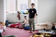 Two men, who identified themselves as Najibullah, right, and Roz Amin Khan, left, stand in their sleeping quarters of a squatted building in Brussels, Tuesday, Jan. 31, 2023. Many refugees and asylum-seekers are literally left out in the cold for months as the European Union fails to get its migration system working properly. And most talk is about building fences and repatriation instead of working to improve a warm embrace for people fleeing nations like Afghanistan where the Taliban has taken over. (AP Photo/Olivier Matthys)