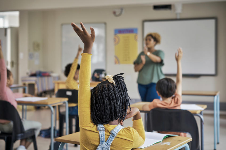 Kids with their hands raised in the air