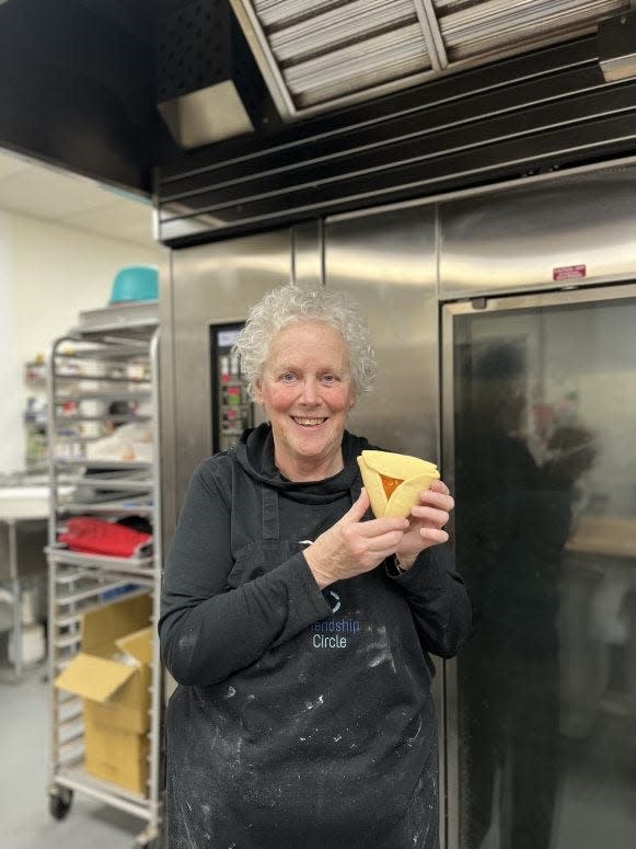 Baker Shari Weingrod shows off a freshly baked apricot hamantaschen at Friendship Bakery