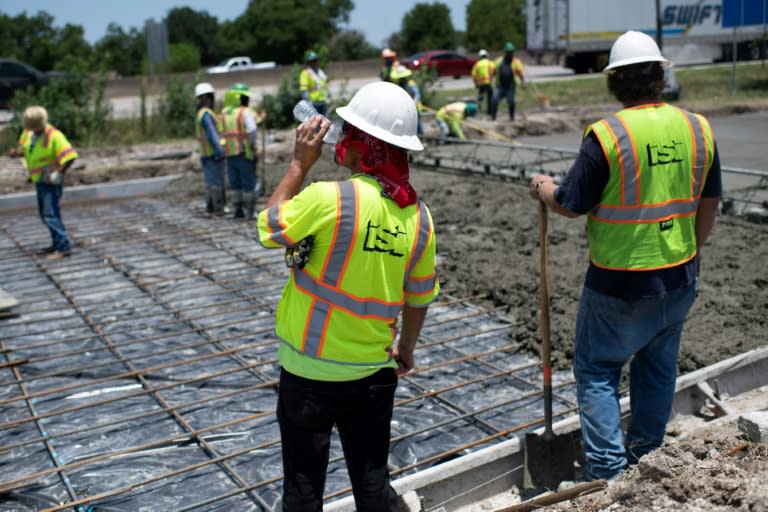 Des ouvriers travaillent pour réparer une route endommagée à cause de la chaleur à Houston, au Texas, le 27 juin 2023 (AFP - Mark Felix)