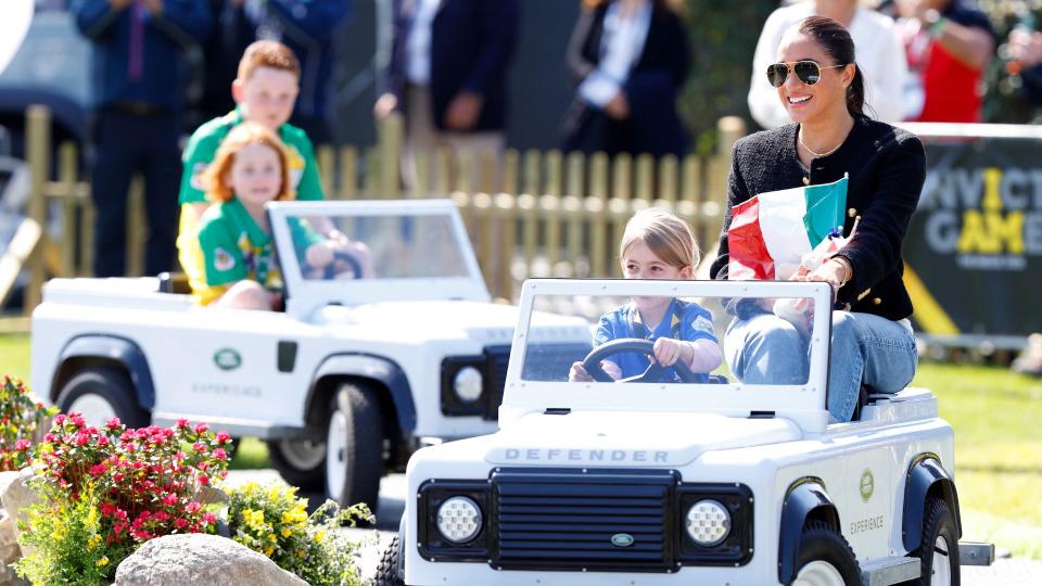 Meghan Markle driving around on a toy car