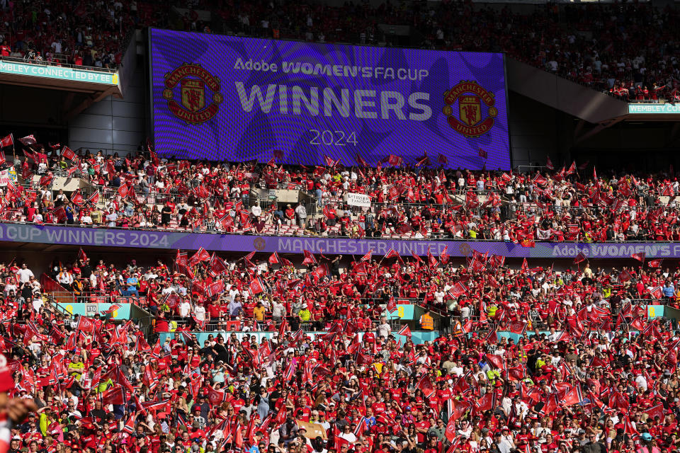 Manchester United fans on the stands celebrate after winning the Women's FA Cup final soccer match between Manchester United and Tottenham Hotspur at Wembley Stadium in London, Sunday, May 12, 2024. Manchester United won 4-0. (AP Photo/Kirsty Wigglesworth)