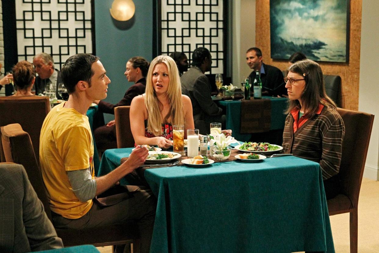 Jim Parsons, Kaley Cuoco, and Mayim Bialik sitting at a table in a restaurant