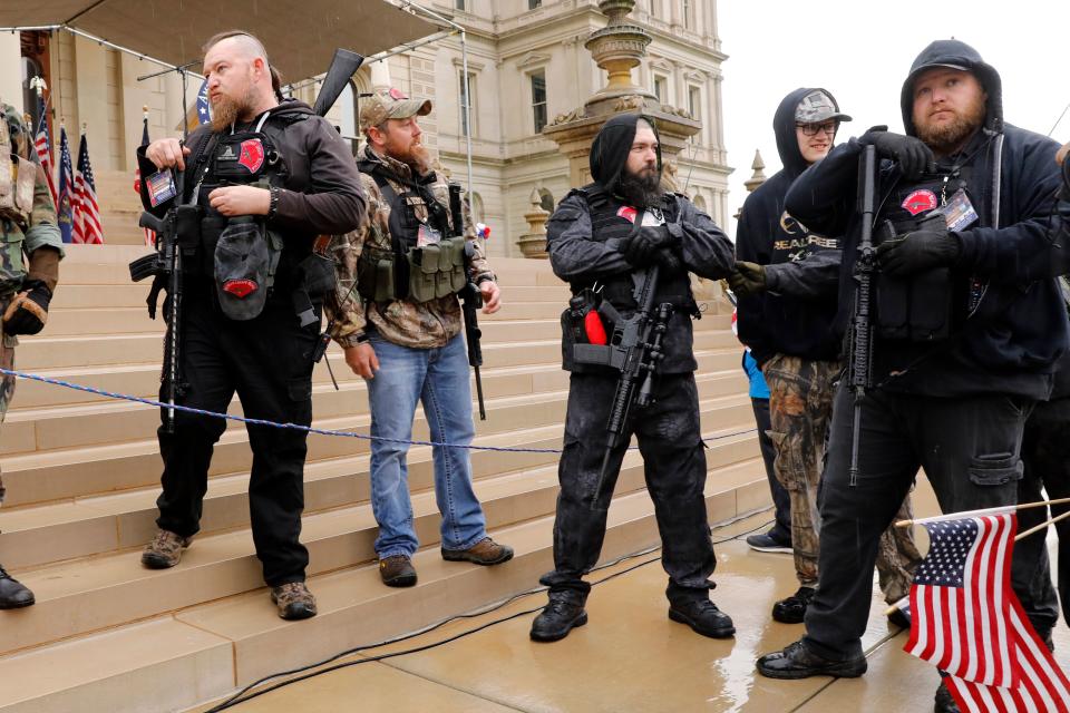 Michael Null (R) and William Null (L) arrive at the American Patriot Rally, organized by Michigan United for Liberty, to demand the reopening of businesses on the steps of the Michigan State Capitol in Lansing, Michigan, on April 30, 2020. Other men are unidentified. - Thirteen men, including members of two right-wing militias, have been arrested for plotting to kidnap Michigan Governor Gretchen Whitmer and "instigate a civil war", Michigan Attorney General Dana Nessel announced on October 8, 2020. The Nulls were charged for their alleged roles in the plot to kidnap Whitmer, according to the FBI. The brothers are charged with providing support for terroristic acts and felony weapons charges. (Photo by JEFF KOWALSKY / AFP) (Photo by JEFF KOWALSKY/AFP via Getty Images)