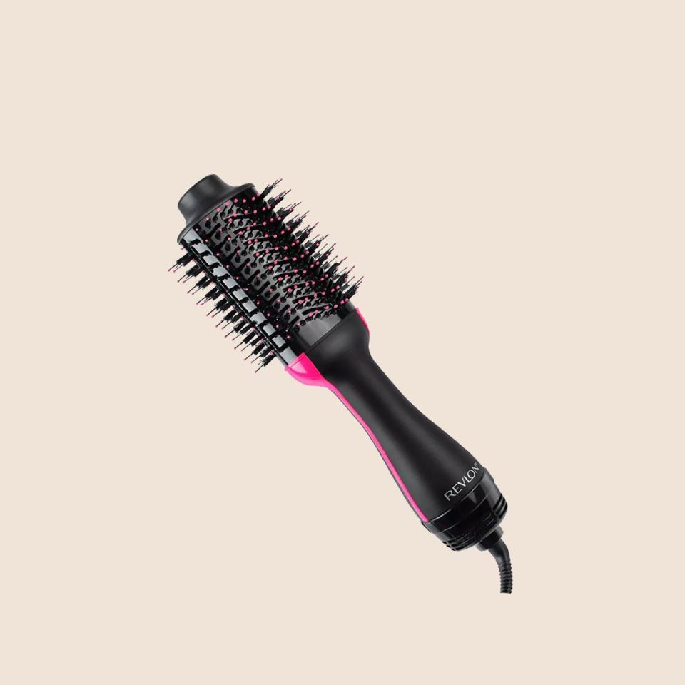 brush hair dryer in front of tan background