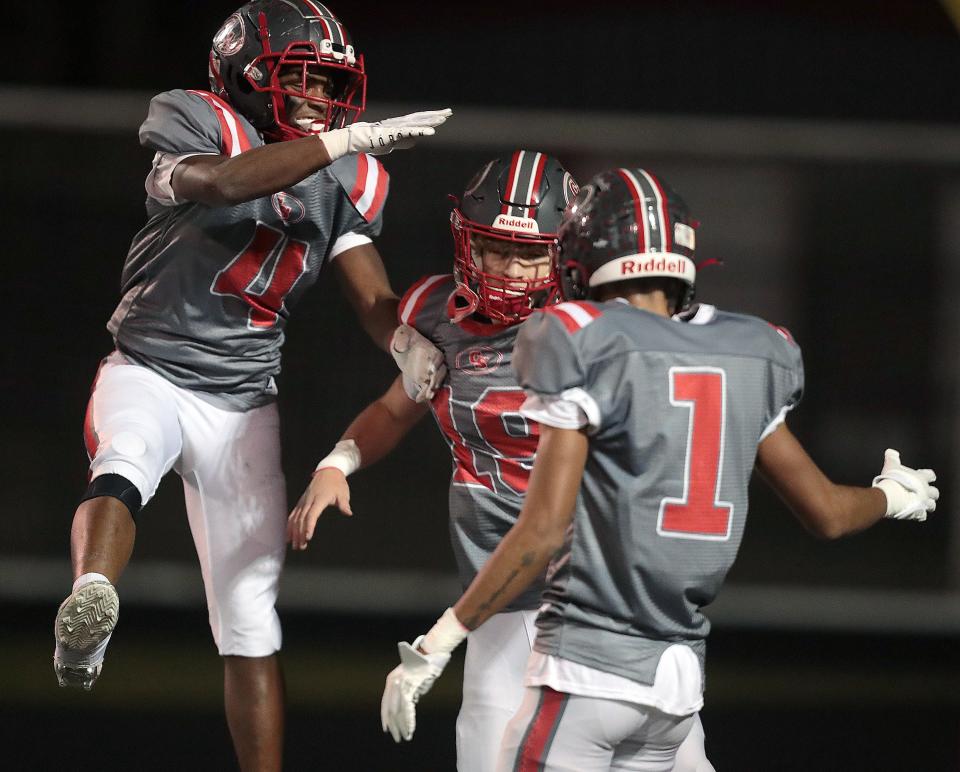 Canton South's Xion Culver (4), Poochie Snyder (19) and Xavier Williams (1) celebrate their win over Northwest, Friday, Oct. 21, 2022.