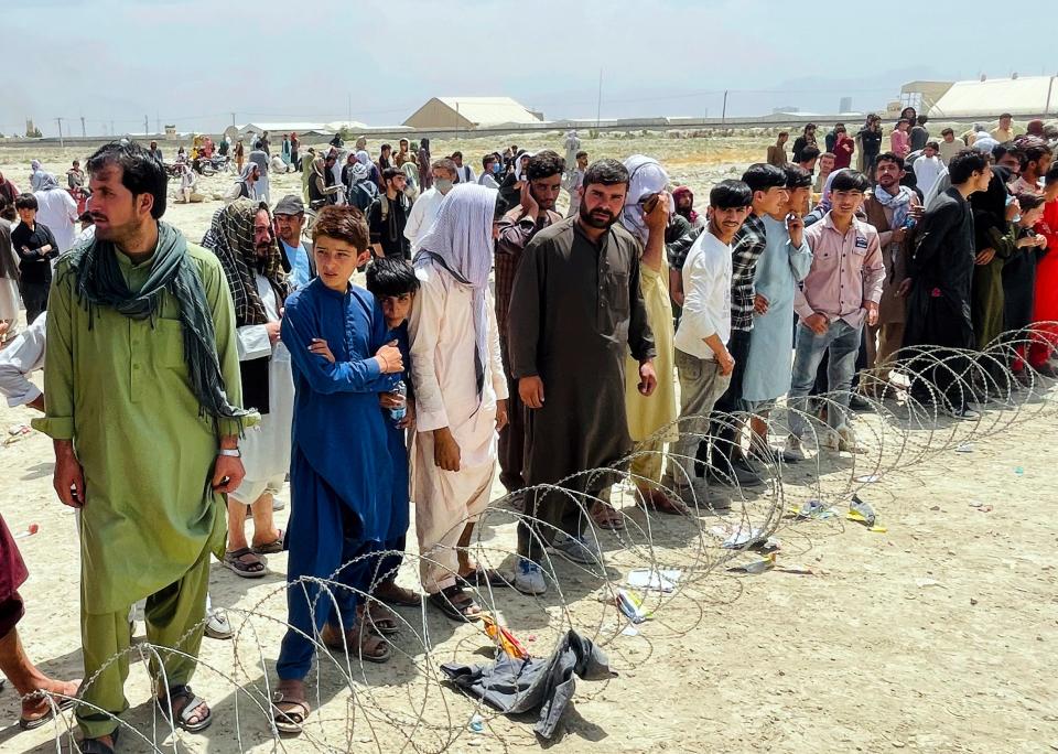 Hundreds of people gather outside the international airport in Kabul, Afghanistan, on Aug. 17. The Taliban declared an “amnesty” across Afghanistan and urged women to join their government, seeking to convince a wary population that they have changed as desperate crowds tried to flee the country.