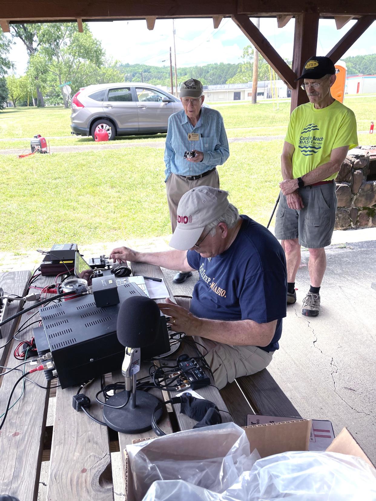 Jim Bogard of the ORARC demonstrates his expertise at the CW station during ARRL Field Day 2021 as fellow hams observe.