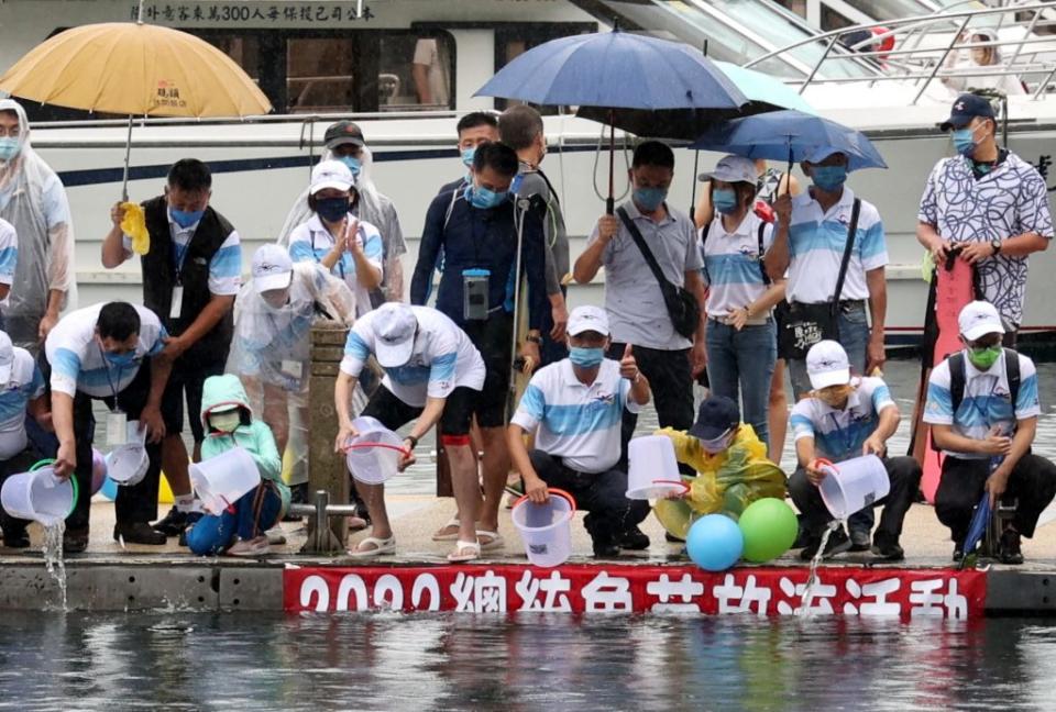 日月潭國際萬人泳渡嘉年華盛會，前總統馬英九、南投縣長林明溱等人，在水社碼頭施放一萬條曲腰魚苗。（記者陳金龍攝）