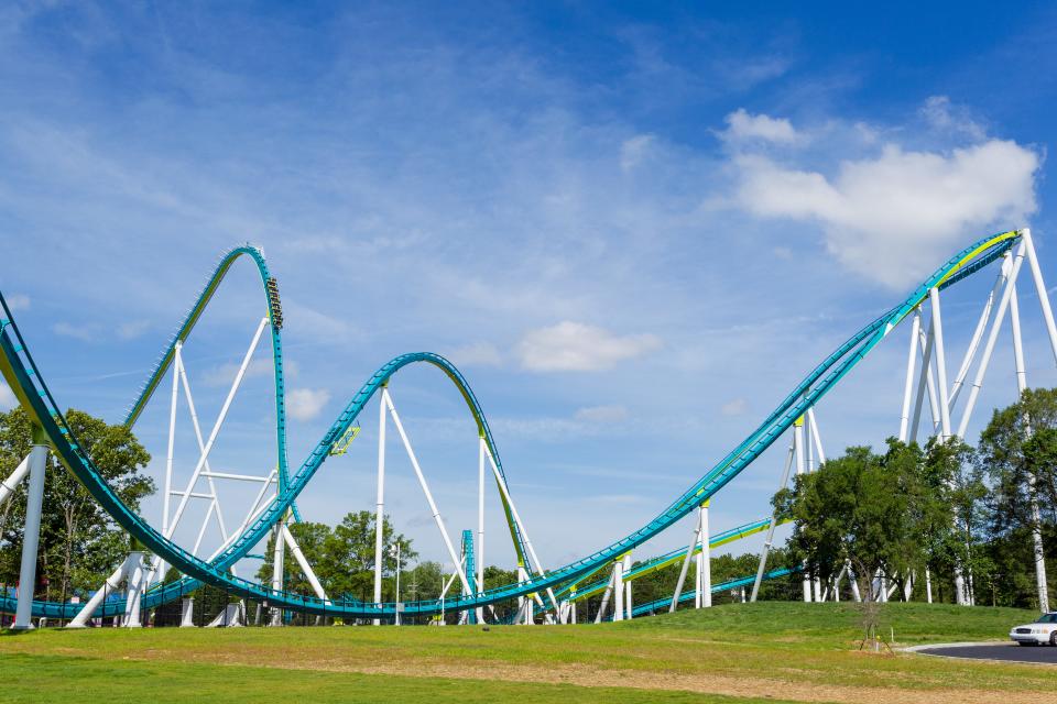 A wide view of the Carowinds Fury 325 roller coaster, which has a long blue track that leads towards an incline before sloping back toward the ground.